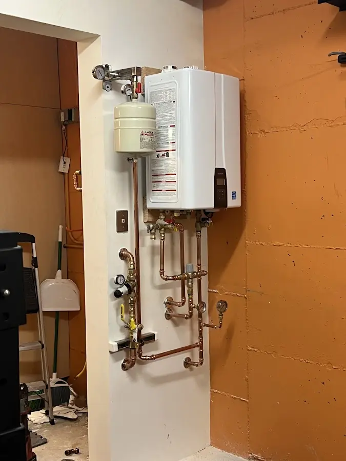 Plumbing technician inspecting water heater connections in Battlefield